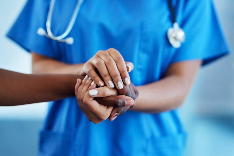 Professional sanitari agafa les mans d'un pacient